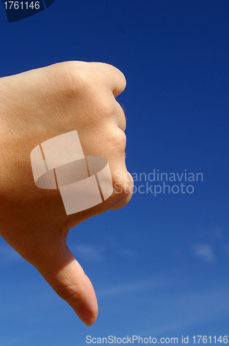 Image of Thumbs down under blue sky