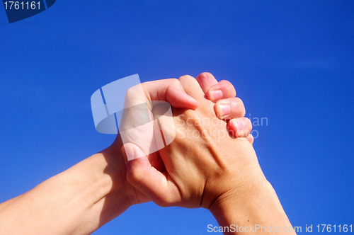 Image of Holding hands under blue sky