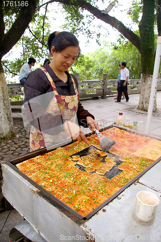 Image of Chinese woman selling tofu on street