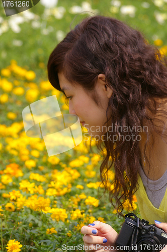 Image of Asian woman looking flowers