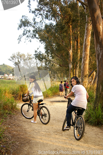 Image of Asian friends riding bicycle