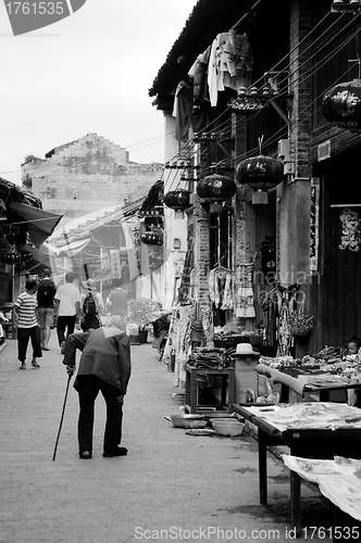 Image of An old woman walking along the street