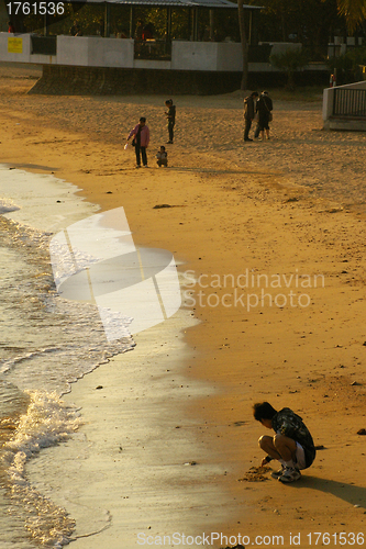 Image of Children playing on beach under sunset