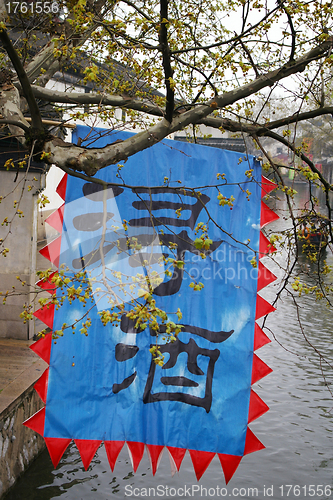 Image of Nanxun water town in China, with famous wine flag.