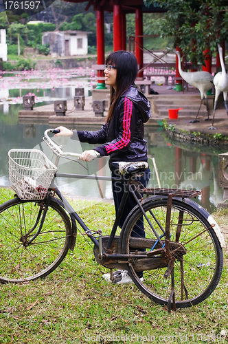 Image of Asian woman riding bicycle with smile