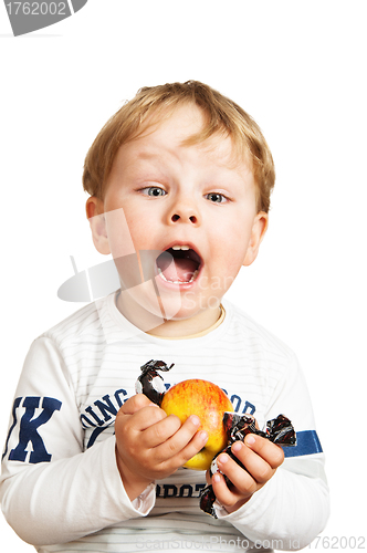 Image of The little boy with an apple and sweets
