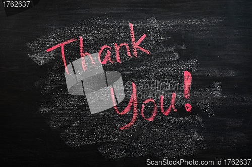 Image of Thank you written with red chalk on a smudged blackboard