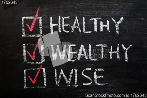 Image of Being healthy, wealthy and wise written with chalk on a blackboard