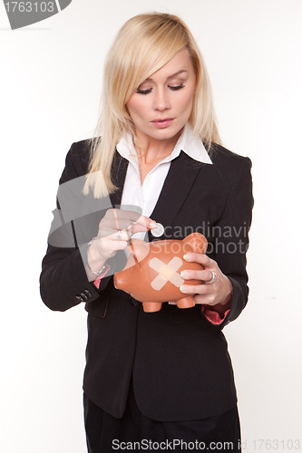 Image of Woman holding piggy bank with a plaster