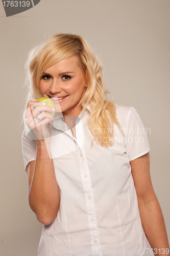 Image of Smiling woman eating an apple