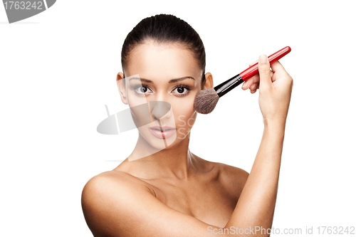 Image of Young beautiful woman applying makeup