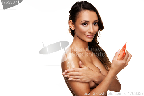 Image of Sexy young female rubbing creme on herself