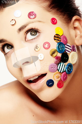 Image of Beautiful woman with buttons on her face