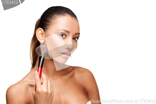 Image of Young beautiful woman using brush to apply makeup