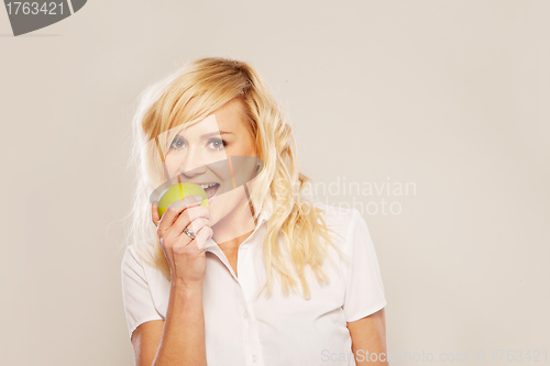 Image of Blonde woman biting an apple