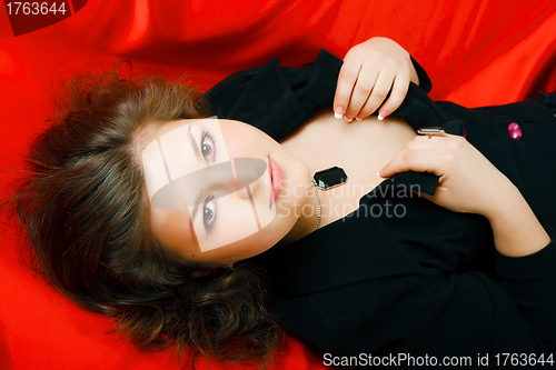 Image of attractive brunette in black on red