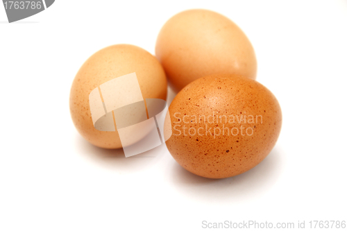 Image of Three eggs lying down on a white linen background