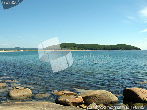 Image of Rocks in the blue sea, illuminated by the sun. Background.