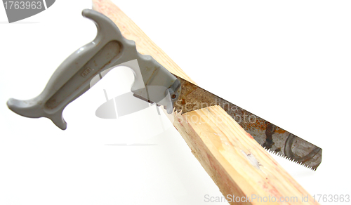 Image of Hacksaw in sawed yellow wooden 
