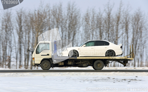 Image of The wrecker carries the car of white color