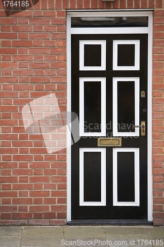 Image of Black and White Door With a Brick Wall