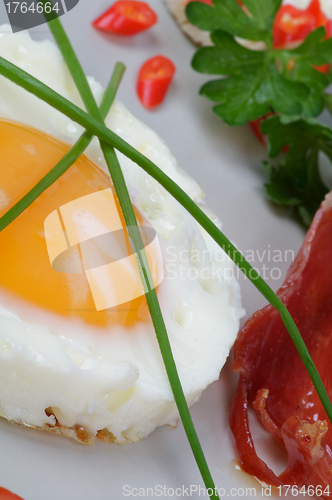 Image of Fried Eggs Sunny Side Up with greens and bacon