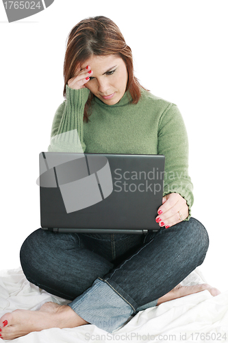 Image of Pretty woman deep in thought while looking at laptop 