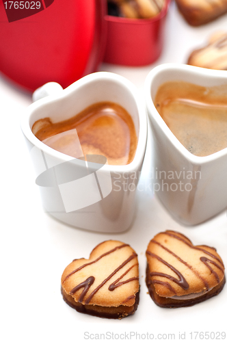 Image of heart shaped cream cookies on red heart metal box and coffee