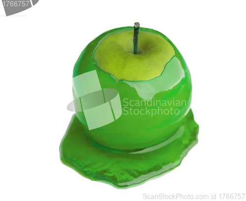 Image of Maple syrup being poured on a green apple on white