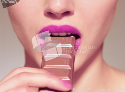 Image of Closeup  woman eating chocolate bar