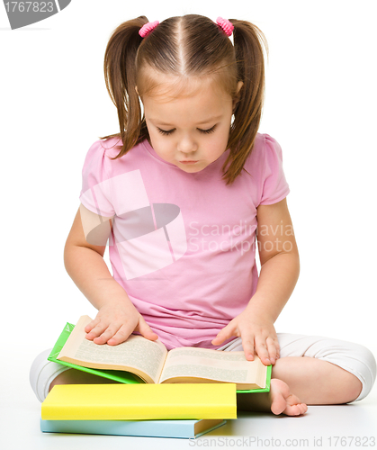 Image of Cute little girl reads a book