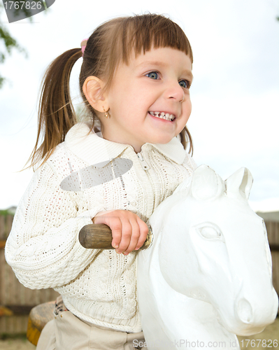 Image of Little girl is swinging on see-saw