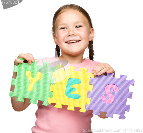 Image of Cute little girl is holding Yes slogan