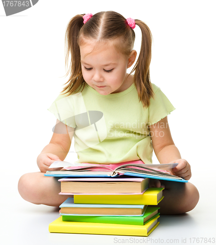 Image of Cute little girl reads a book