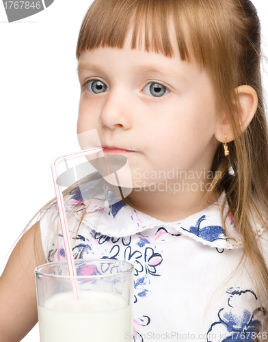 Image of Cute little girl drinks milk using drinking straw