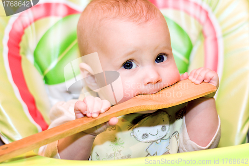 Image of baby biting a wooden spoon