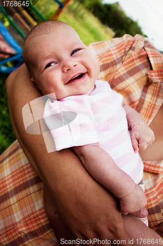 Image of baby girl in her fathers hands