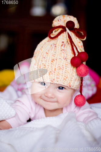 Image of cute baby girl in yellow hat with bobbles