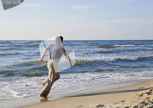 Image of Man running along seashore