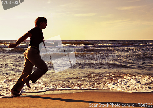 Image of Man running along seashore