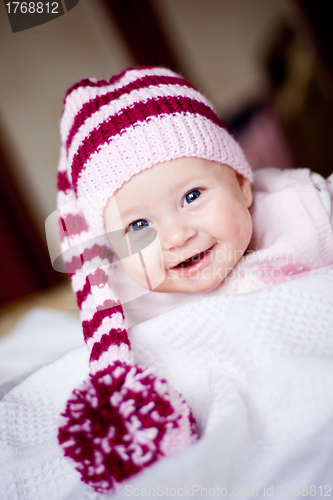 Image of smiling baby girl in hat with pompom