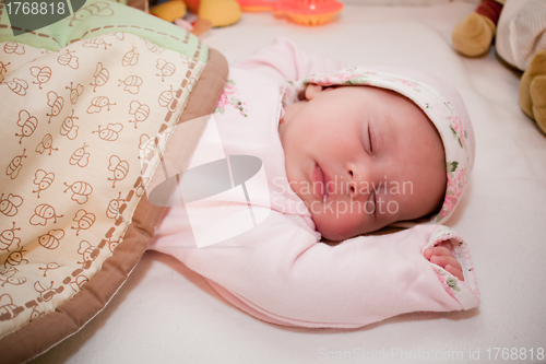 Image of sleeping peaceful baby girl in a pink pagama