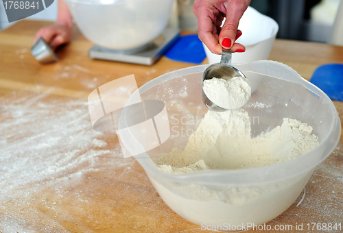 Image of Female hand collecting flour from bowl