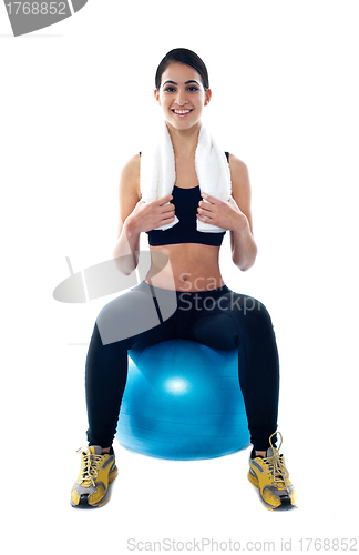 Image of Attractive female athlete sitting on blue ball