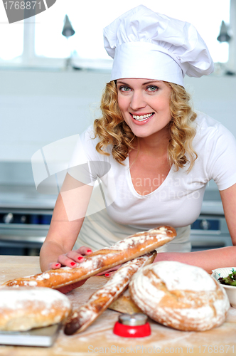 Image of Cheerful female cook posing in kitchen