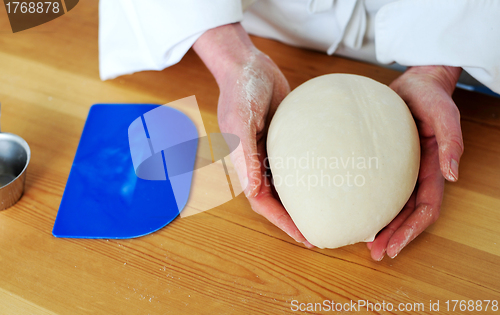 Image of Chefs hand holding a clean finished dough