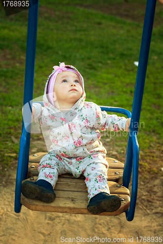 Image of little girl  on the swings