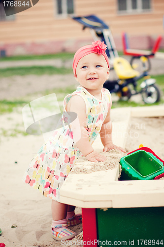 Image of Cute girl playing with the sand