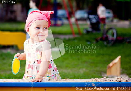 Image of Cute girl playing with the sand