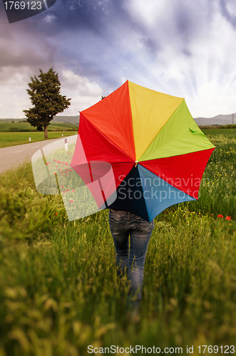Image of Girl with umbrella at field with Dramatic Sky
